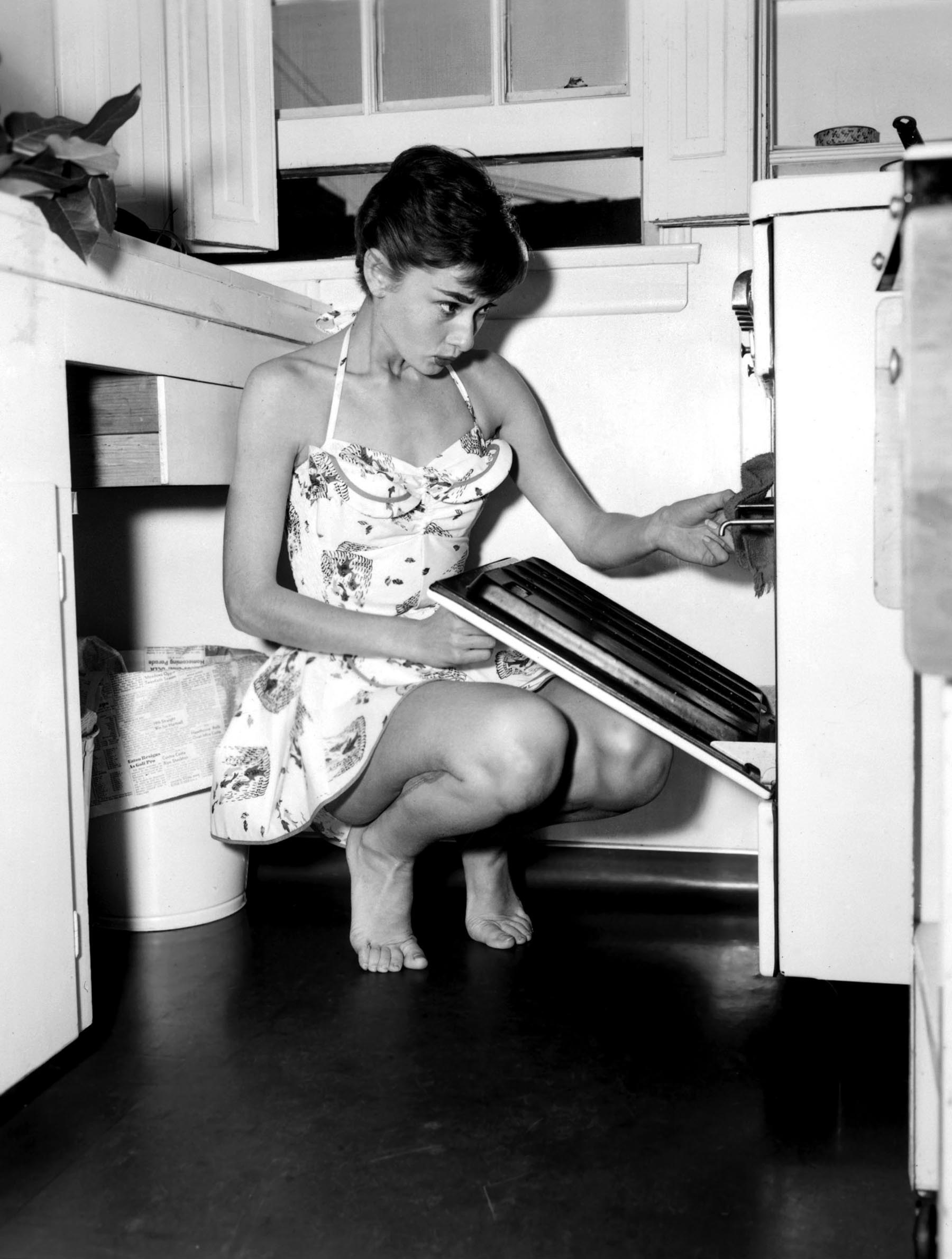Audrey Hepburn using an oven
